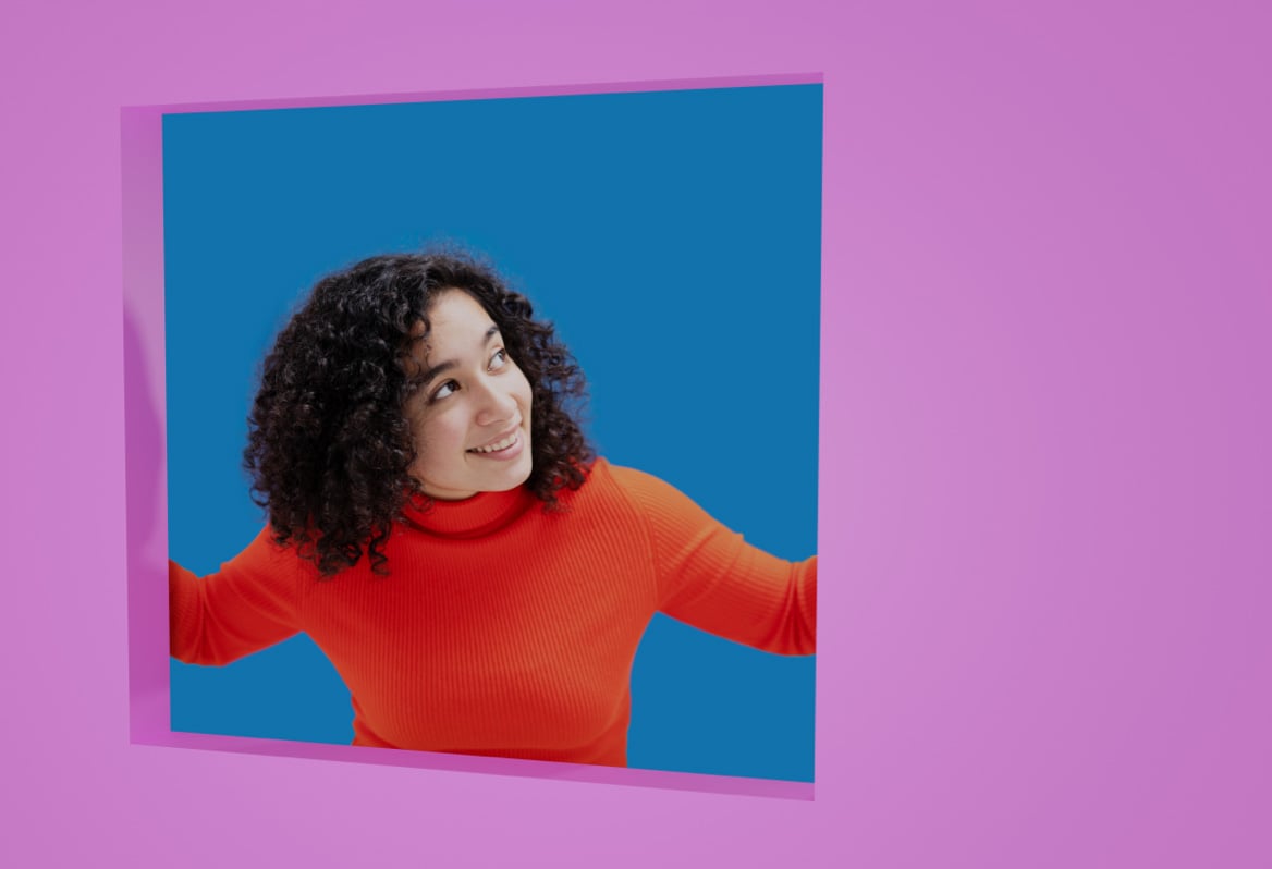 woman in an orange jumper looking out of a blue frame