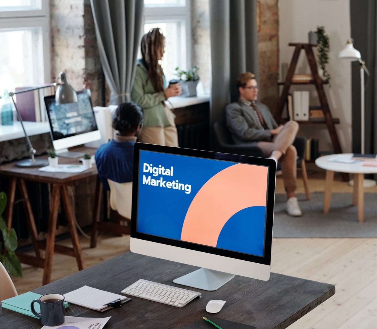 studio desk with an iMac showing a marketing deck