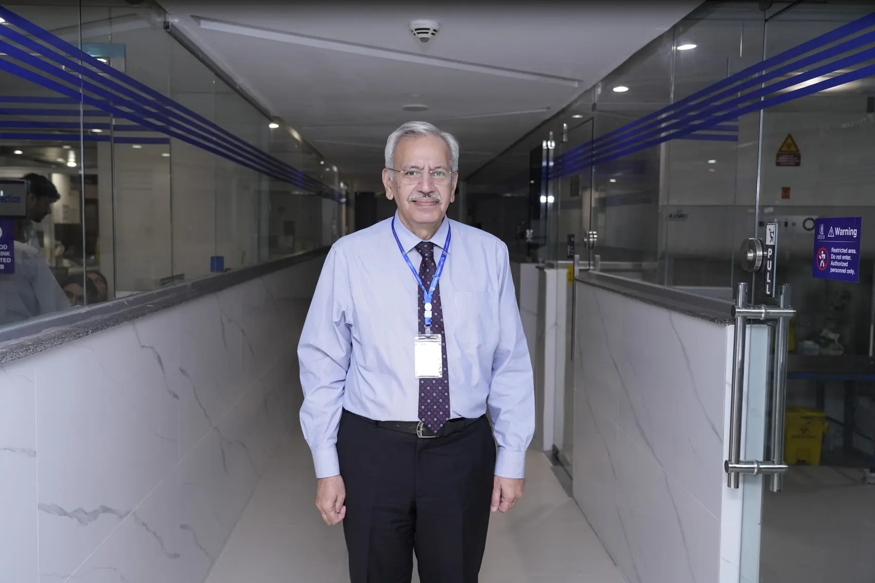 Chughtai Lab, man standing in bright modern lab corridor